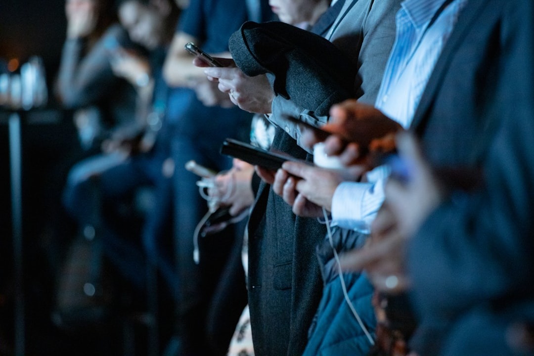 Hands interacting with smartphones in a meeting.
